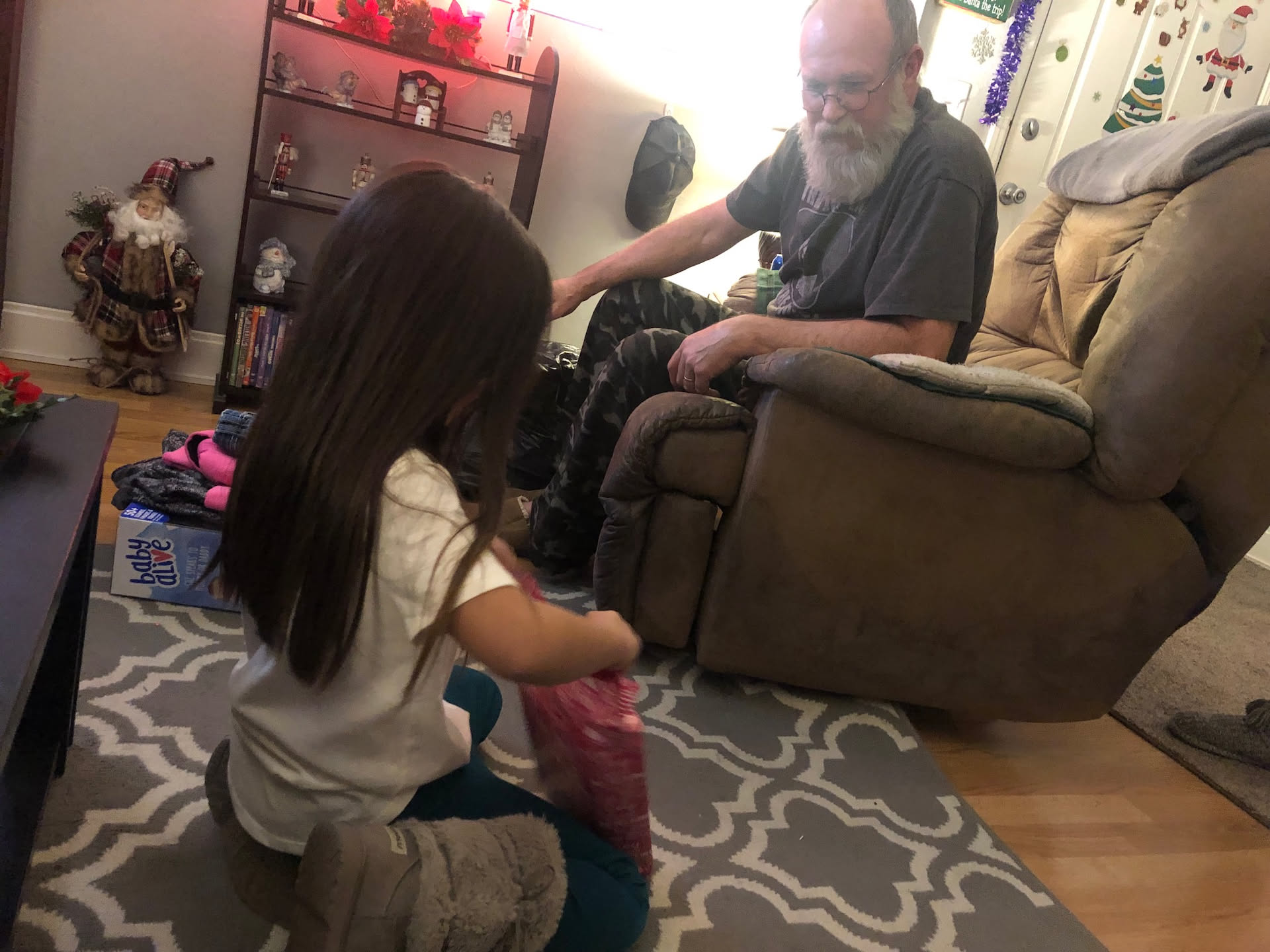 Grandpa loving watching her open.