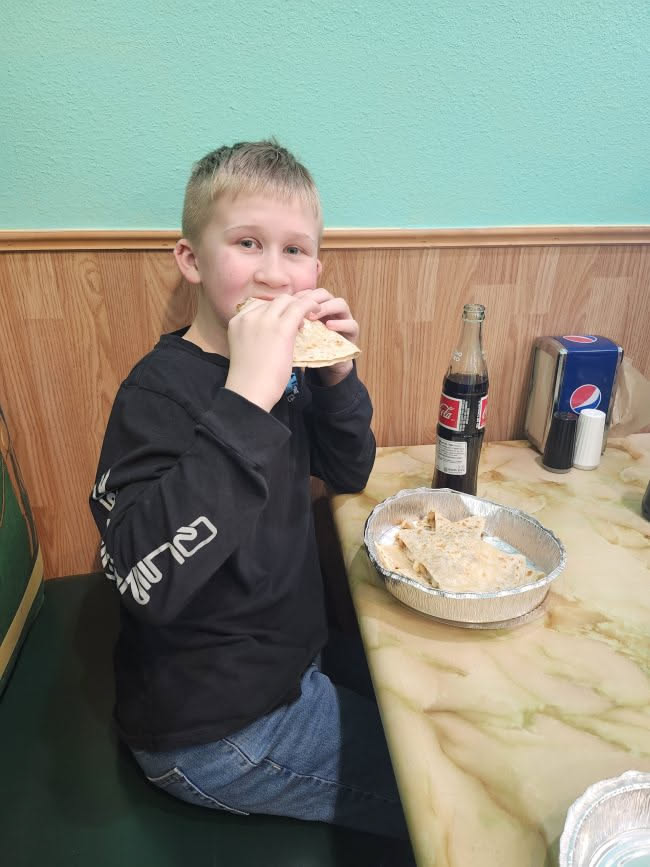 Ethan digging into his quesadilla.