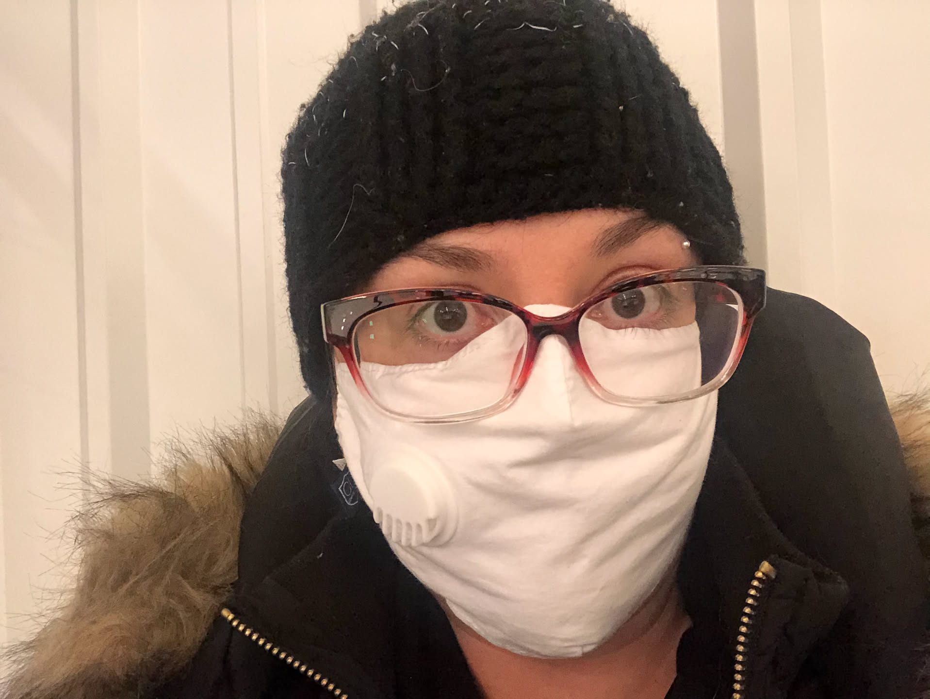 Hockey mom all bundled up, cold, and watching the game!